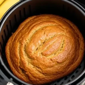 "Air fryer banana bread loaf, golden and moist, served fresh from the air fryer."