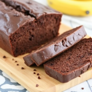 Chocolate chip banana bread loaf with slices on a wooden table