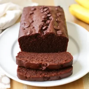 Freshly baked chocolate chip banana bread loaf with banana slices.